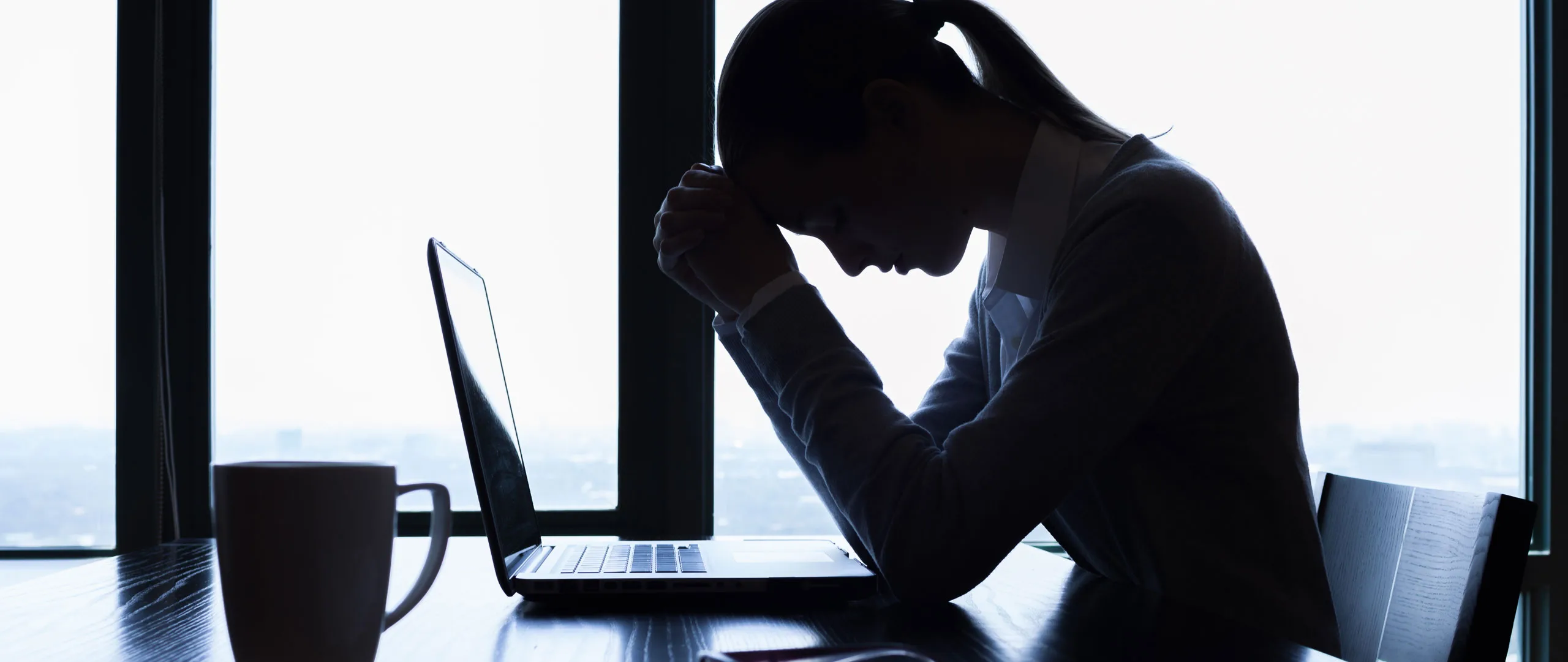 Woman at work with head on hands