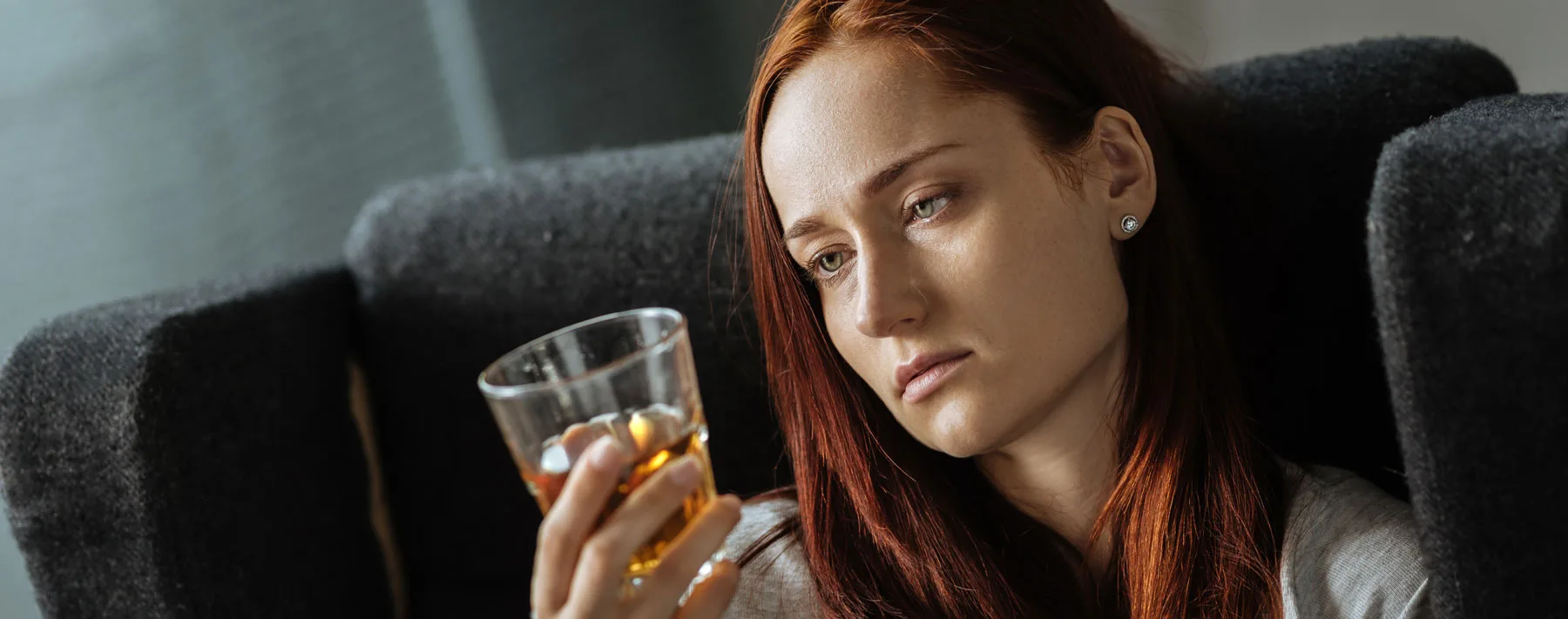 Woman looking at drink in her hand