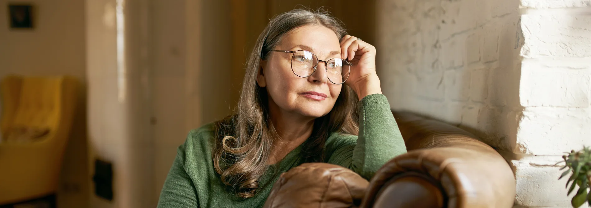 Woman sitting on couch looking out window