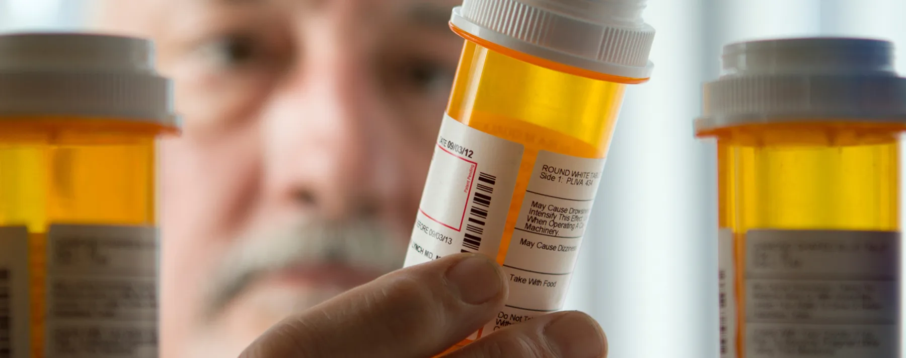 man taking medicine out of cabinet