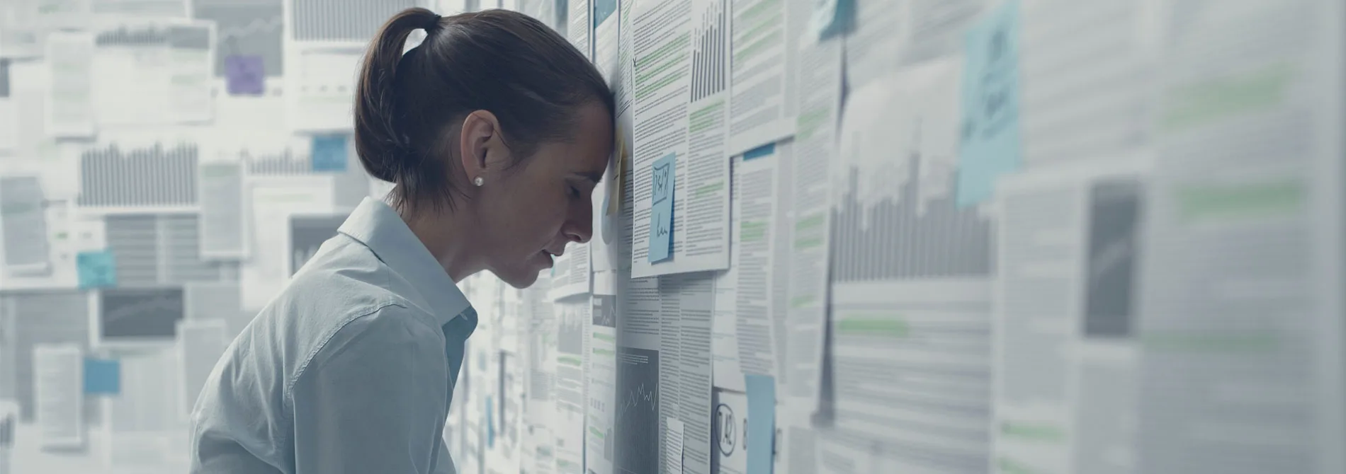 stressed woman with head against the wall