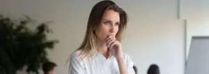 Woman with hand to her mouth looking sad
