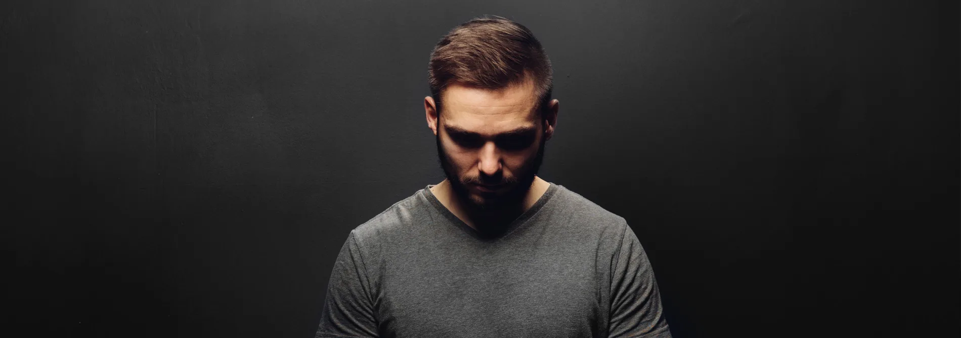 man on dark background looking down